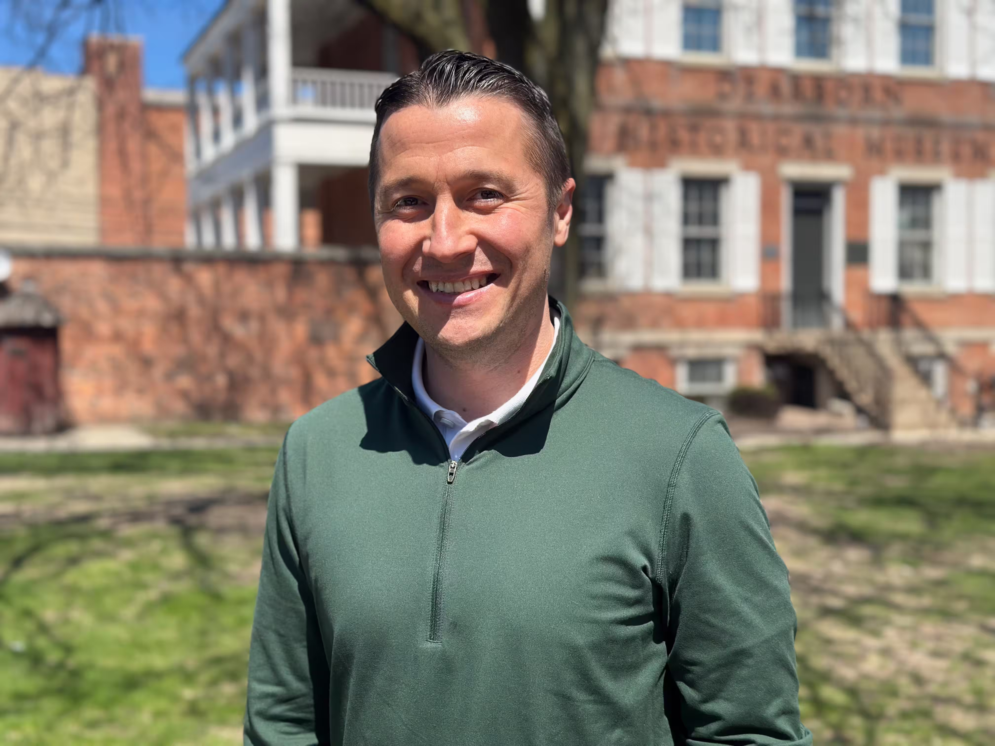 Devon standing and smiling in front of the Dearborn Historical Museum.