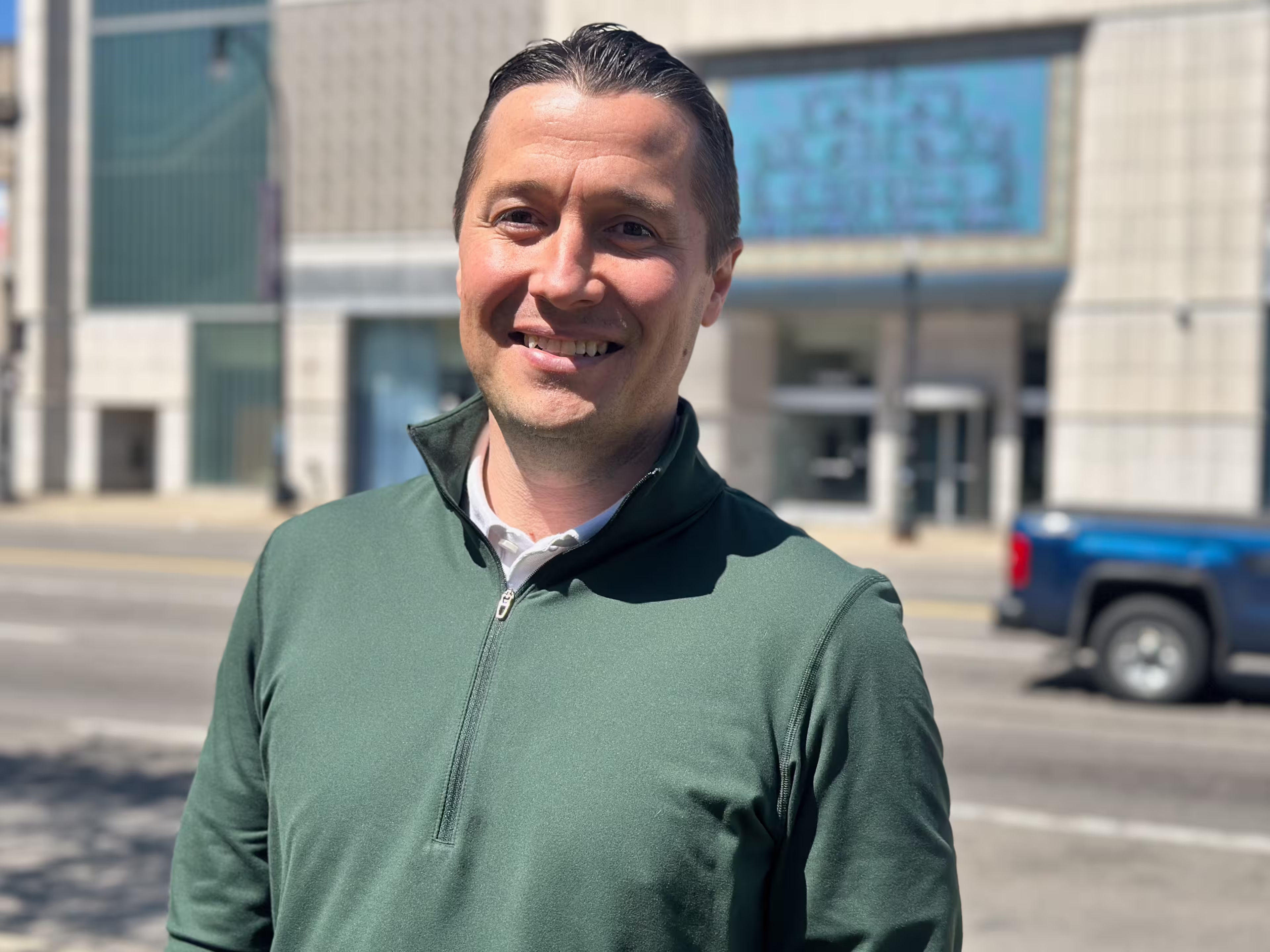 Devon smiling and standing in downtown Dearborn in front of a building.